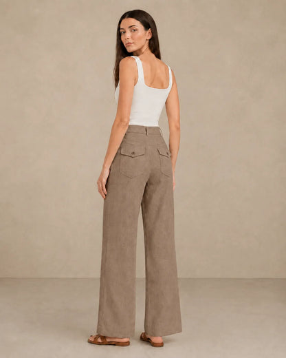 Back view of model wearing latte-coloured linen wide-leg trousers with flap patch pockets.