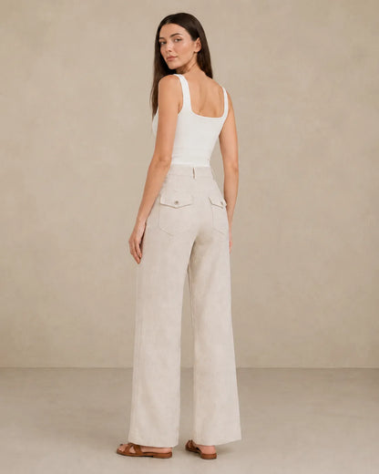 Back view of model wearing natural linen wide-leg trousers with flap patch pockets.