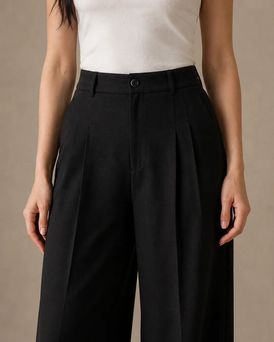 Close-up of the pleated high waistband on black wide-leg linen-tencel-viscose trousers.