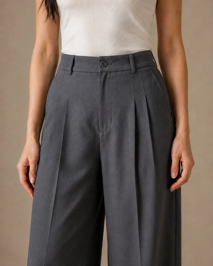 Close-up of the pleated high waistband on dark grey wide-leg linen-tencel-viscose trousers.