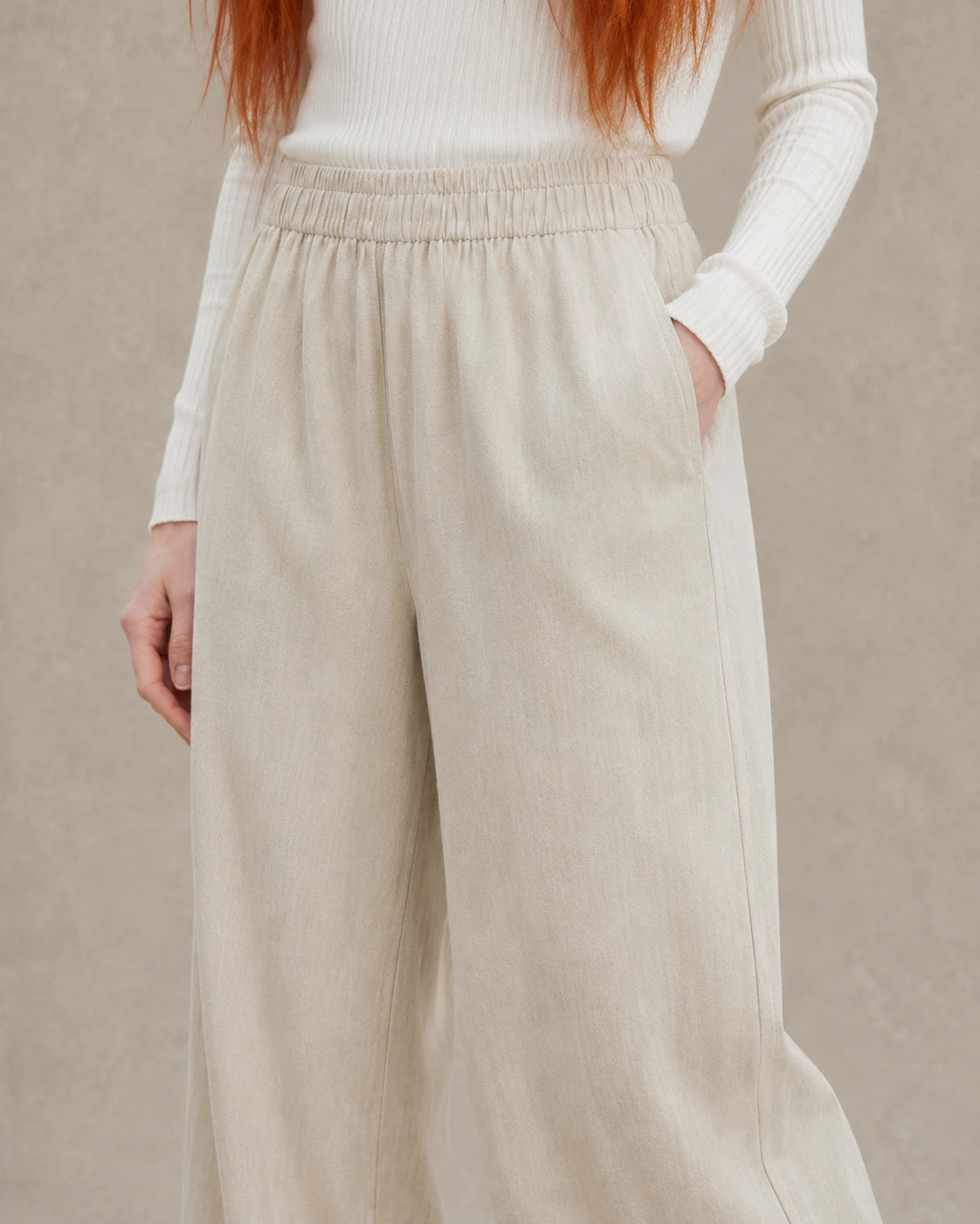 Close-up van de elastische taille en zijzak van een kaki ingekorte wijde broek dames in tencel-linnenmix.