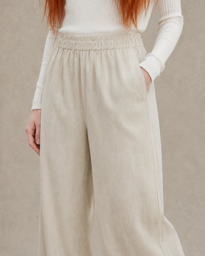 Close-up van de elastische taille en zijzak van een kaki ingekorte wijde broek dames in tencel-linnenmix.