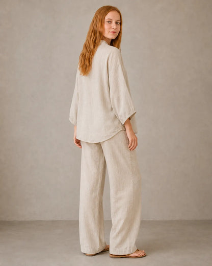 Back view of a model in the khaki cotton-linen co-ord set, showing the loose drape of the shirt over the trousers.