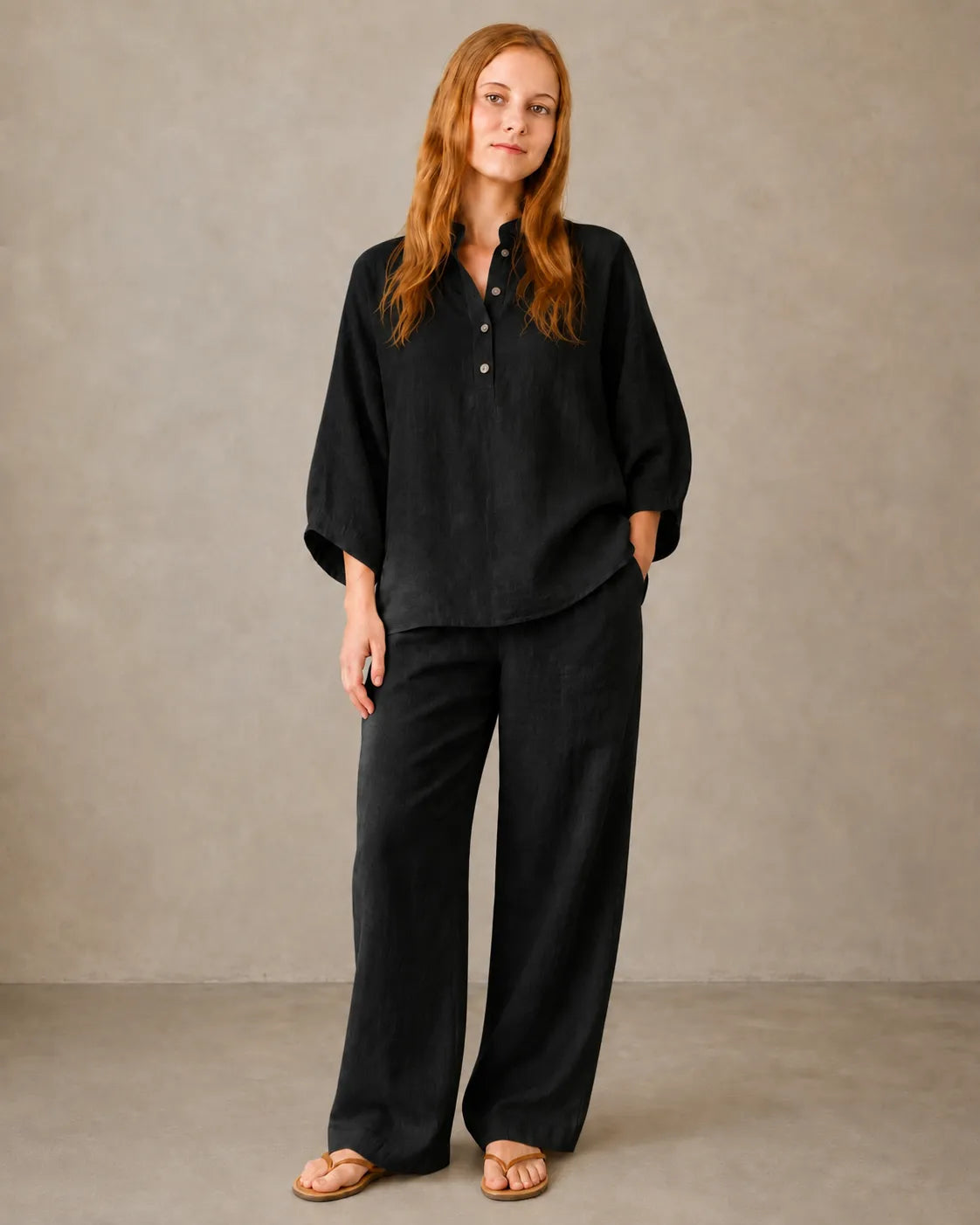 A model wears the black cotton-linen co-ord set, styled with a long-sleeve collared shirt and matching trousers.