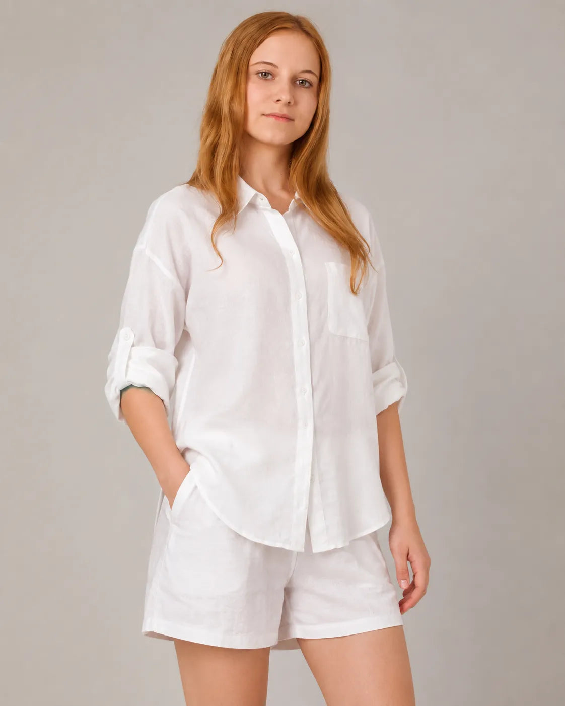 A model wears the linen-cotton co-ord set in white, turned to show the button-down shirt with a chest pocket and matching shorts.