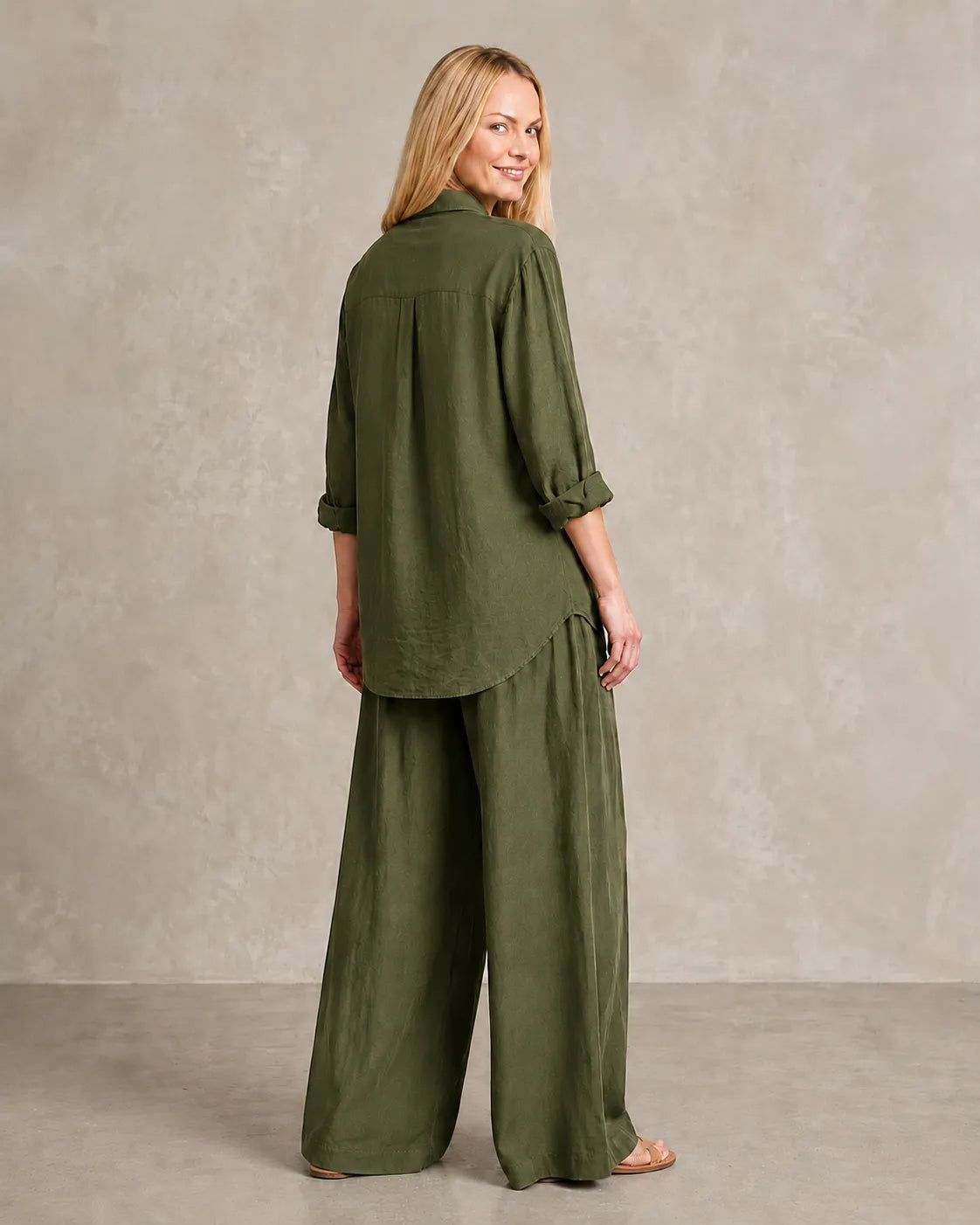 Achteraanzicht van de legergroene linnen co-ord set, met de blouse vallend over de wijde broek.