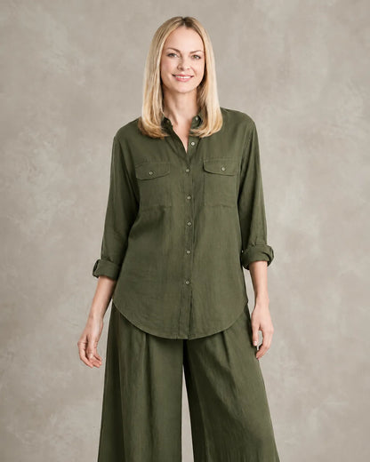 Een dichterbij vooraanzicht van een model in de legergroene linnen co-ord set, met de borstzakken en knoopsluiting van de blouse.