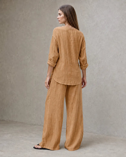 Achteraanzicht van een model in de camelkleurige linnenmix co-ord set met V-hals, met de tuniektop vallend over de geplooide broek.