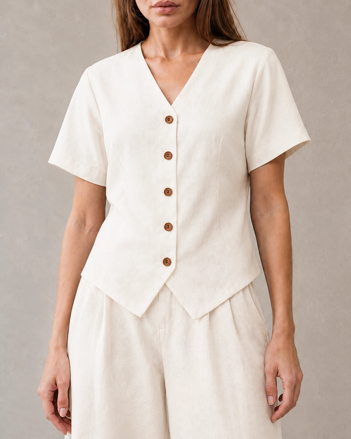 Close-up van de V-hals en houten knopen van de off-white tencel-linnen co-ord set.