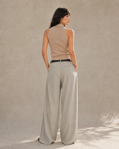 Back view of a woman wearing light gray tencel-linen wide-leg trousers with a high waist.