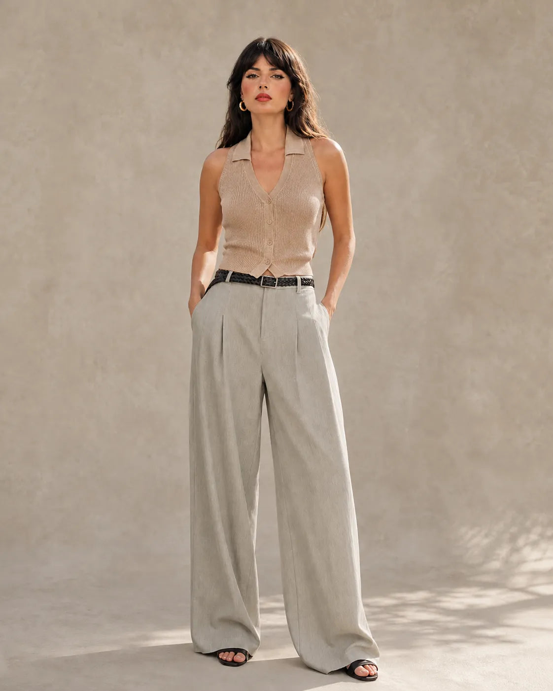 Woman wearing light gray tencel-linen wide-leg trousers with a high waist and front pleats, shown from the front.