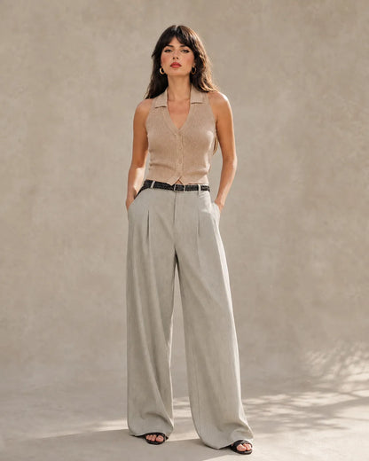 Woman wearing light gray tencel-linen wide-leg trousers with a high waist and front pleats, shown from the front.
