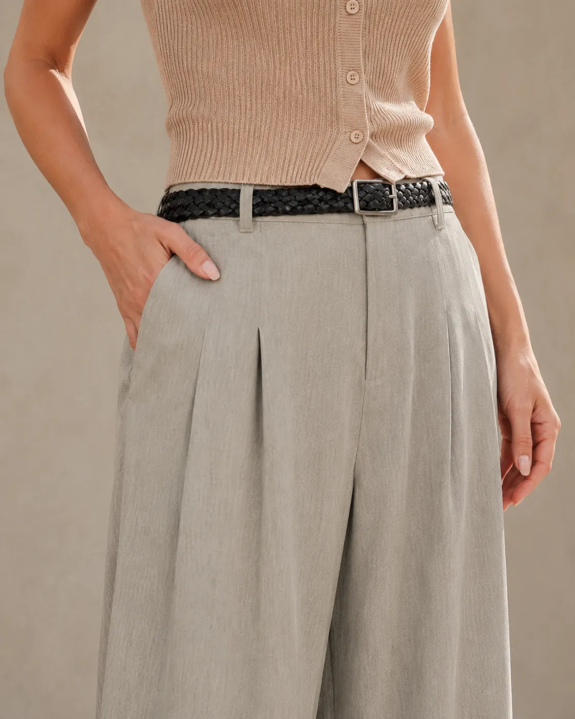 Close-up of the front pleats and side pockets on light gray tencel-linen wide-leg trousers.