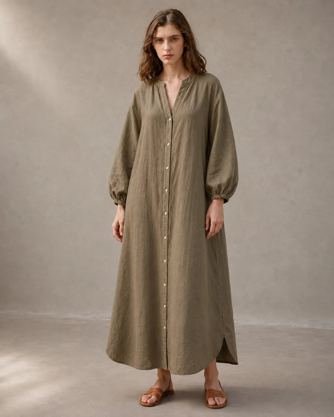 Close-up of a woman wearing a khaki cotton-linen dress, showing the long balloon sleeves with elasticated cuffs.