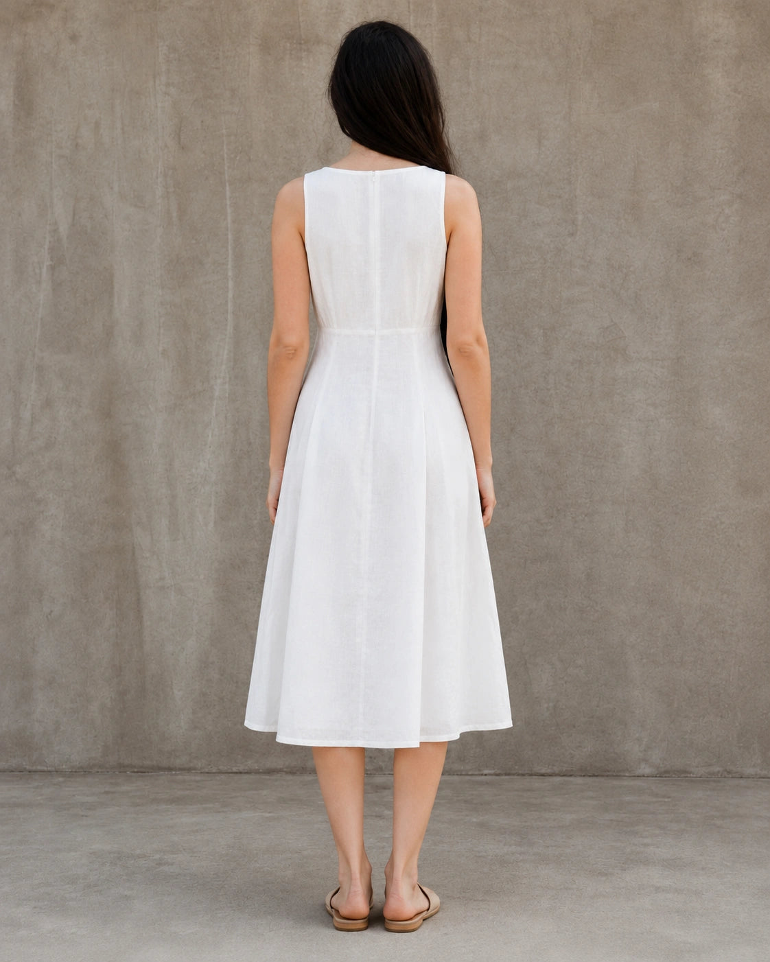 Back view of a white linen-cotton midi dress with a round neckline and A-line skirt, shown on a model.
