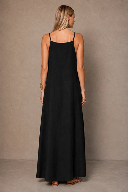 Back view of a black cotton-linen halter dress with thin adjustable straps, shown on a model.