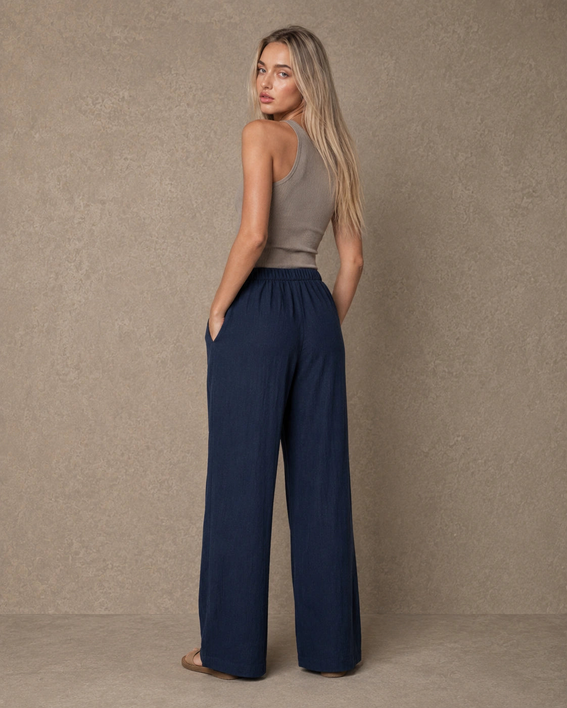 Achteraanzicht van model in een marineblauwe hoge taille pantalon dames in katoen-linnen-viscosemix met elastische taille.