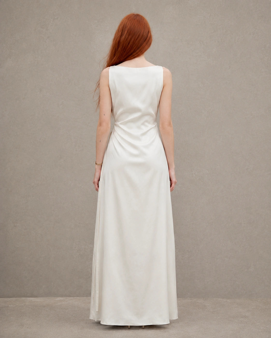 Back view of an apricot tencel-linen fitted dress with a fitted A-line skirt, shown on a model.
