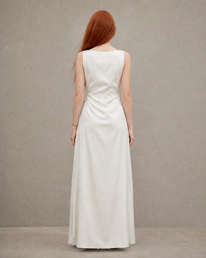Back view of an apricot tencel-linen fitted dress with a fitted A-line skirt, shown on a model.