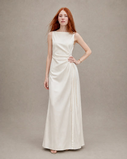 Woman wearing an apricot tencel-linen fitted dress, hand on hip, shown from the front.