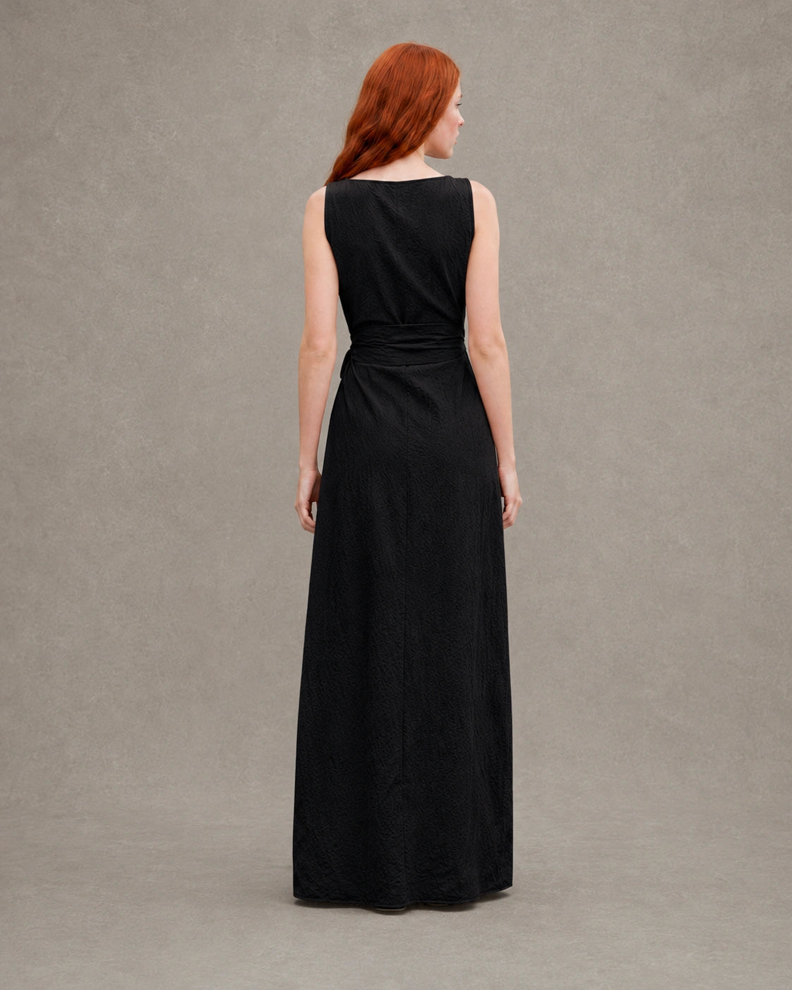 Back view of a black tencel-linen fitted dress, showing the waist tie and back seam detail, shown on a model.