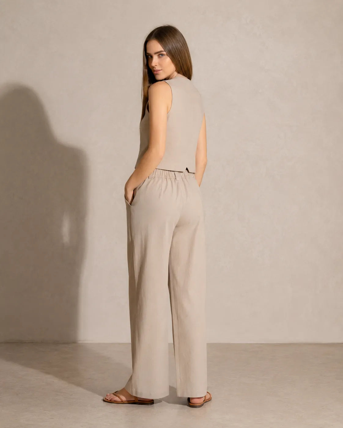Achteraanzicht van een model in de kaki co-ord set, met zicht op de elastische taille van de wijde broek.